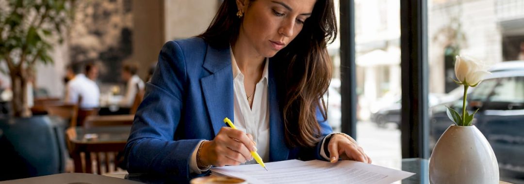 Businesswoman reviewing employment contracts at desk