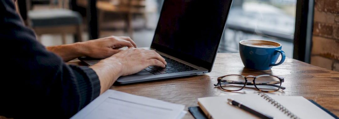Hands entering data on laptop for Social Security