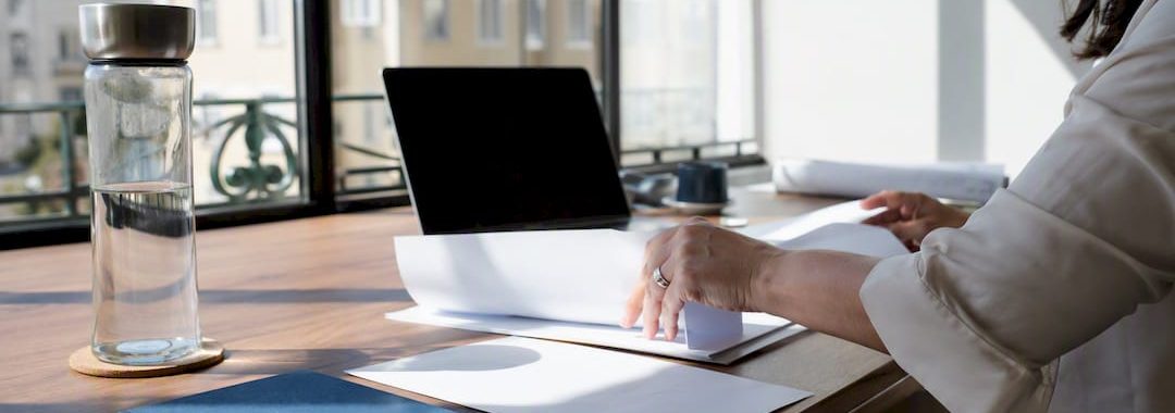 Hands handling employment contracts and compliance papers