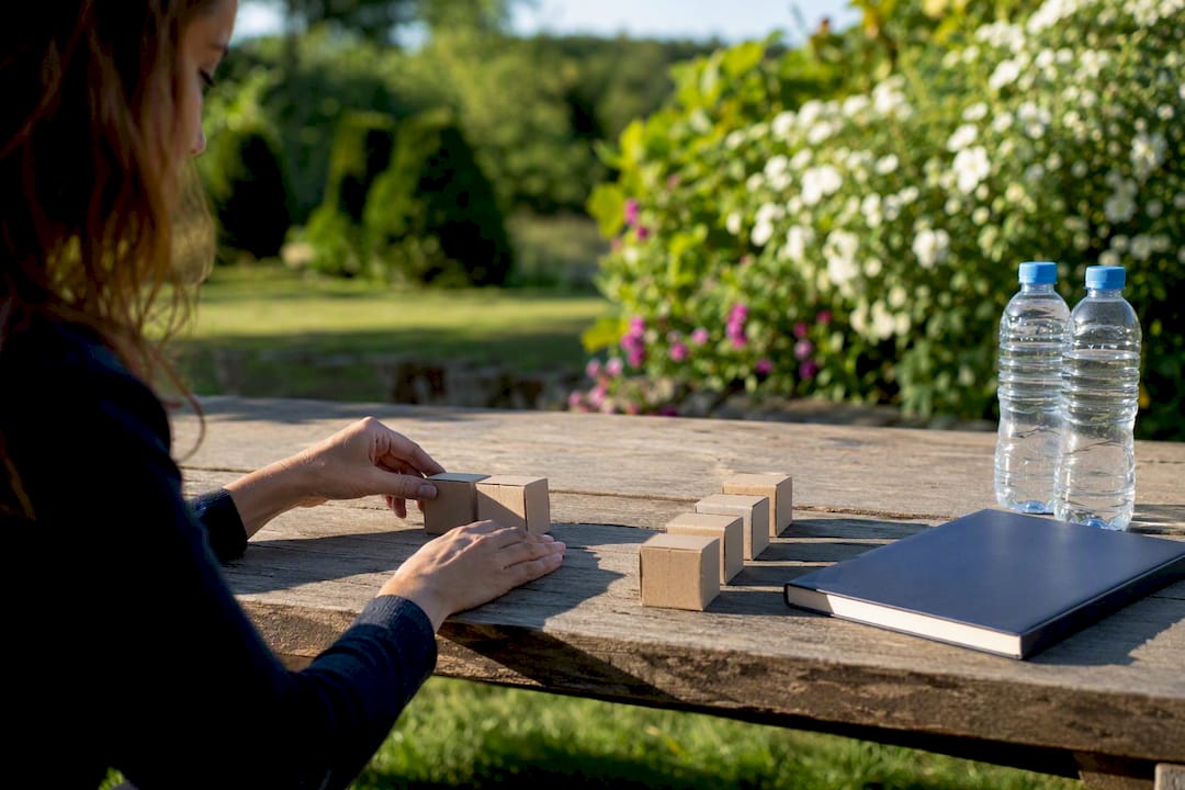 Hands arranging business decision blocks on table