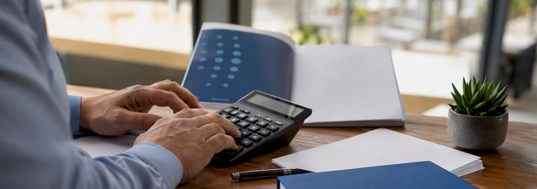 Hands calculating payroll tax with Portuguese tax table